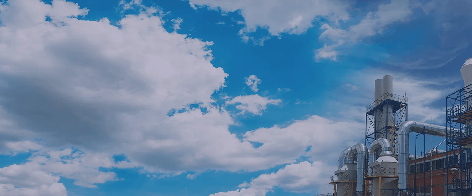 Cielo limpio sobre planta industrial con scrubbers y ductos metálicos — MCAT