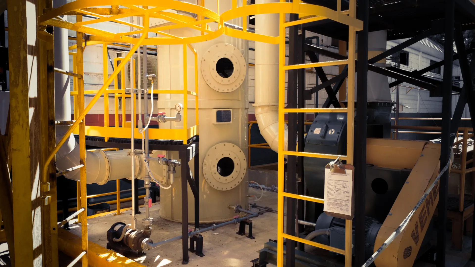 Lavador de gases industrial MCAT instalado en planta INFRA con estructura de soporte metálica amarilla.
